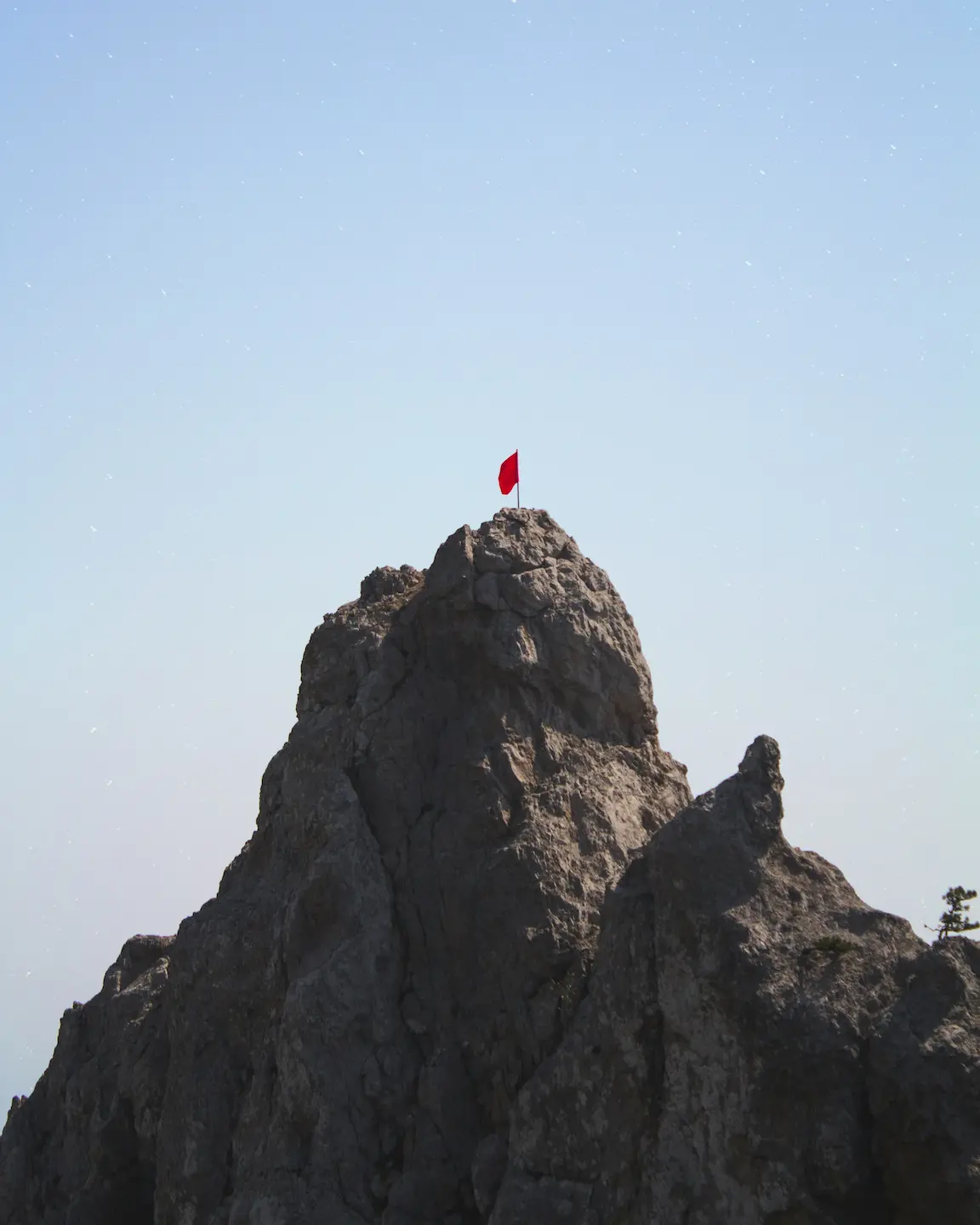 mountain with red flag on top